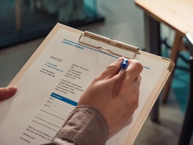 Person's hand holding a company invoice on a clipboard with a pen. Writing childcare center quotes: a template plus priced examples