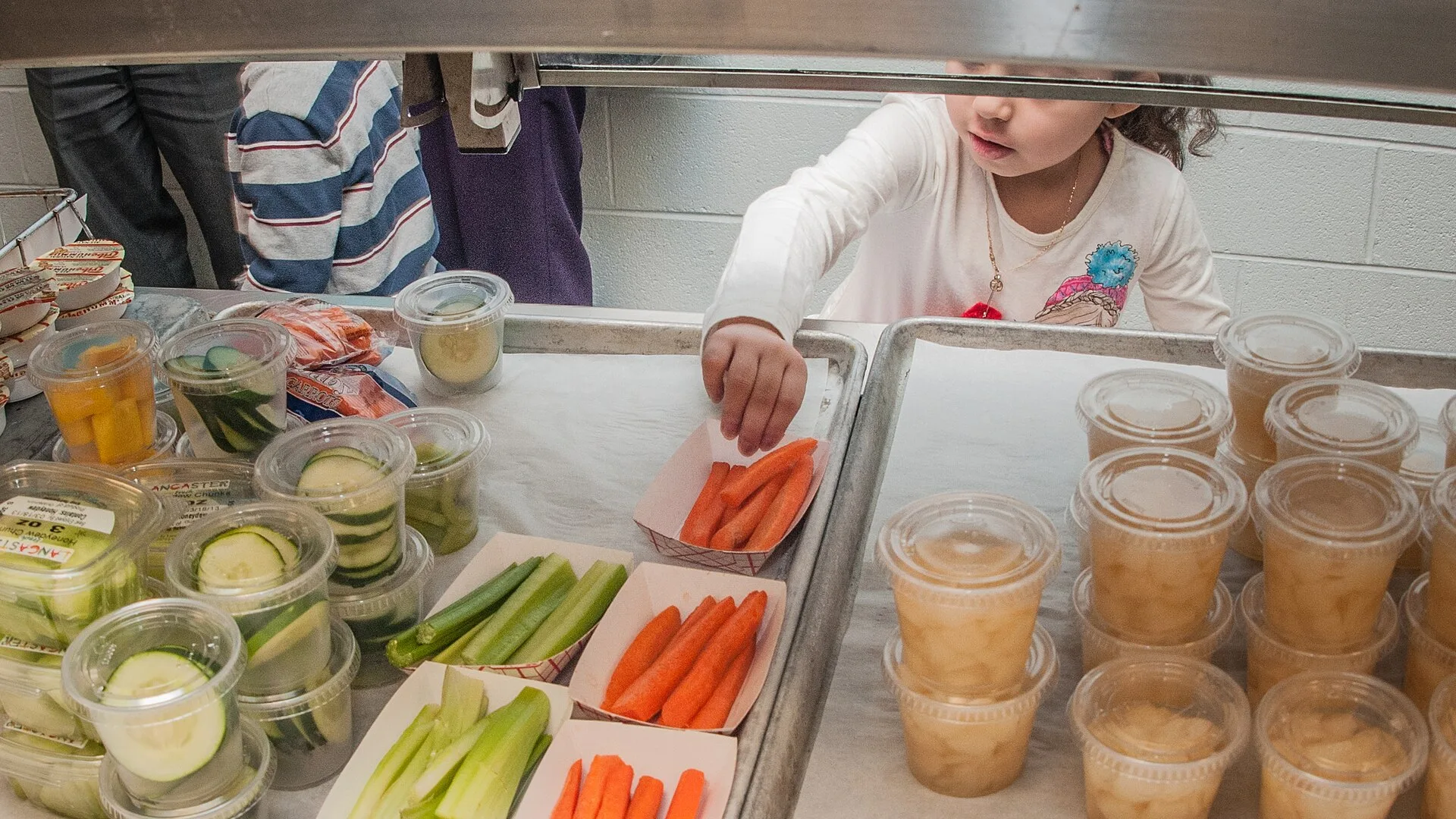 A Harmony Hills Elementary School student picks one of her two side selections as her class picks up their lunches and head to their tables, in Silver Spring, MD, on Thursday, March 7, 2013. Harmony Hills’ 640 students spend about 25 minutes in the cafeteria receiving their food and eating. The proc. Capital for a childcare center: what it takes and where it comes from